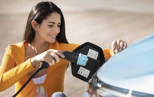 Mujer cargando un coche eléctrico