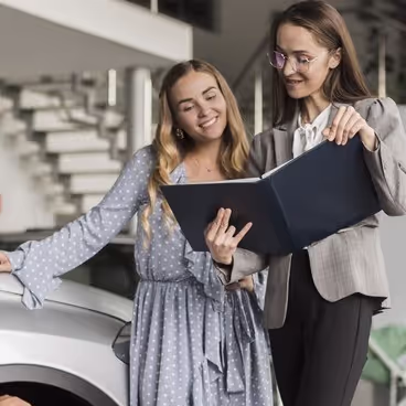 Madre e hija viendo un coche en un concesionario