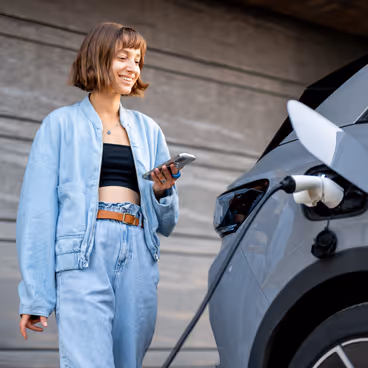 Chica cargando el coche eléctrico