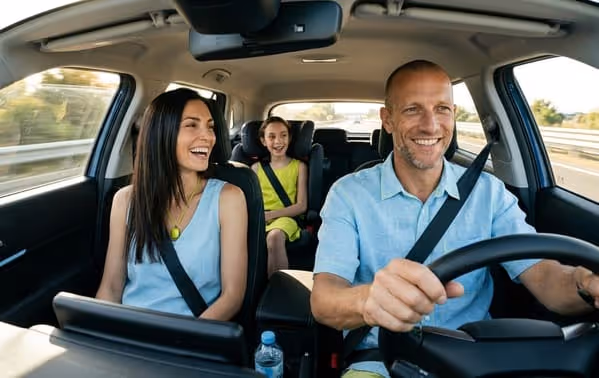 Pareja con móvil frente al coche