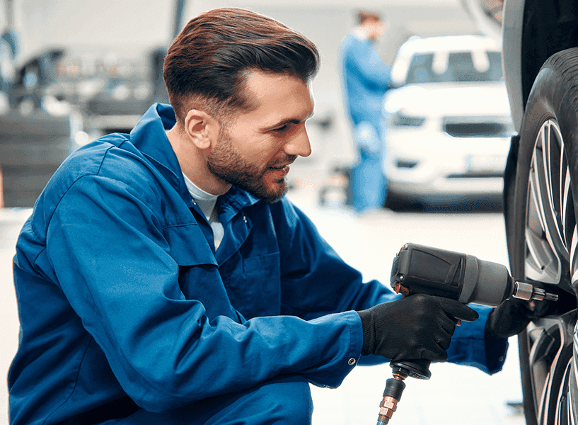 Una mecánica arreglando un coche en un taller